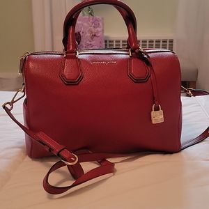 Red Michael Kors handbag with crossbody strap.